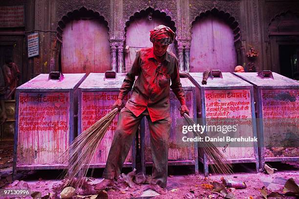 Man cleans the remnants of Holi celebrations at the Bankey Bihari Temple on February 27, 2010 in Vrindavan, India. The tradition of playing with...