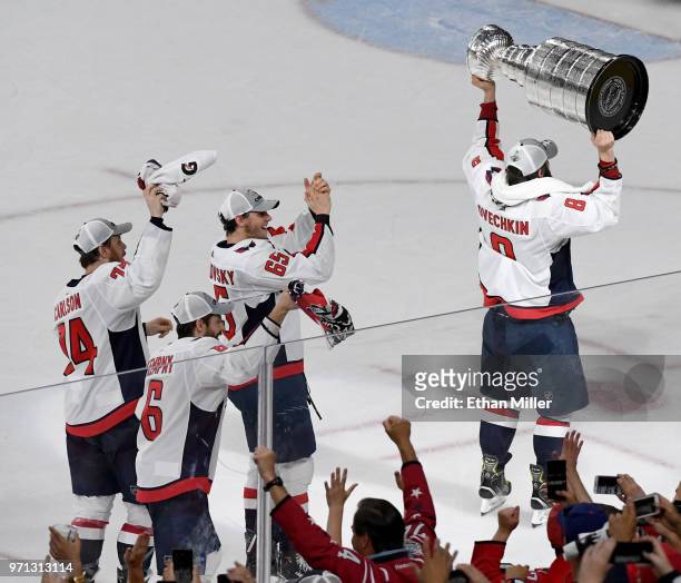 Alex Ovechkin of the Washington Capitals skates around the rink with the Stanley Cup followed by teammates John Carlson, Michal Kempny and Andre...