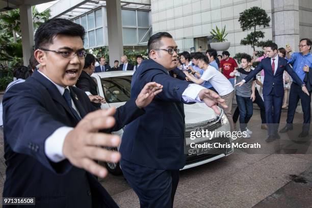 Hotel security staff try to hold back members of the press as the car carrying United States Ambassador to the Philippines Sung Kim tries to leave...