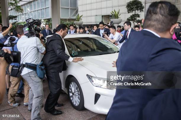 Hotel security staff try to hold back members of the press as the car carrying United States Ambassador to the Philippines Sung Kim tries to leave...