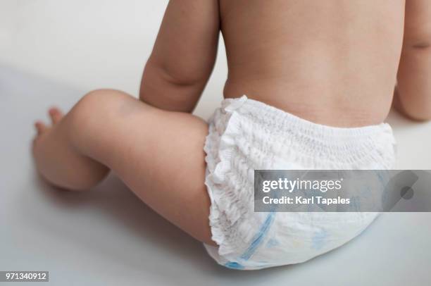 a baby boy is wearing a diaper only - pañal fotografías e imágenes de stock