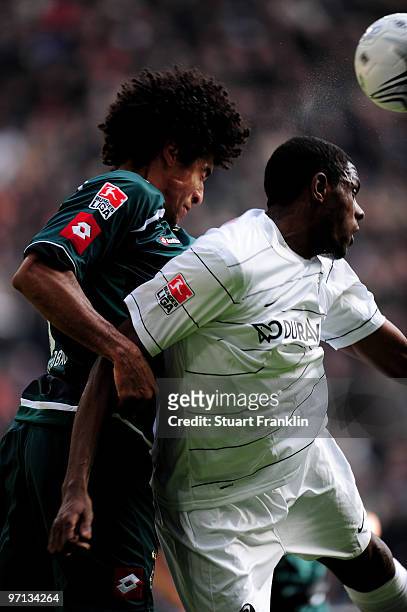 Dante of Moenchengladbach is challenged by Mohamadou Idrissou of Freiburg during the Bundesliga match between Borussia Monchengladbach and SC...