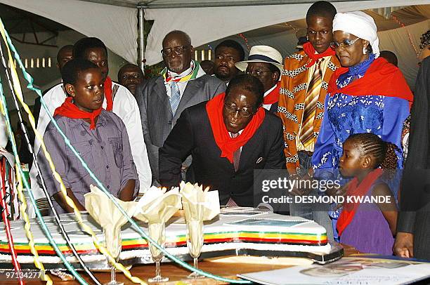 Zimbabwean President Rorbet Mugabe blows the candles on his birthday cake on February 27, 2010 during celebrations to mark his 86th birthday in...