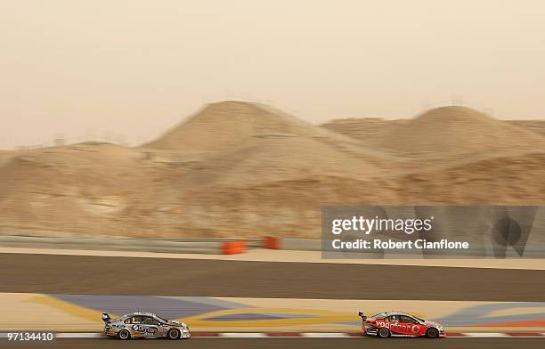 Jamie Whincup driving the Team Vodafone Holden leads Mark Winterbottom driving the Ford Performance Racing Ford during race two for round two of the...