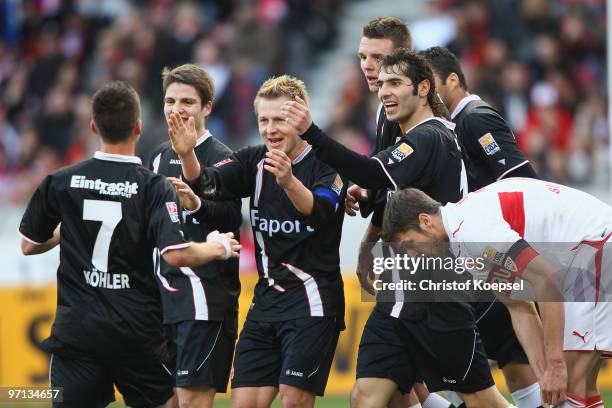 Benjamin Koehler of Frankfurt celebrates the first goal with his team and Matthieu Delpierre of Stuttgart looks dejected during the Bundesliga match...