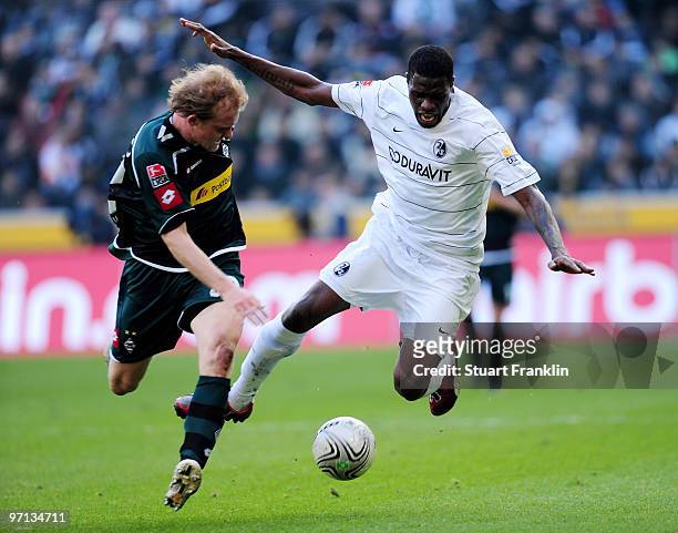 Tobias Levels of Monechengladbach challenges Mohamadou Idrissou of Freiburg during the Bundesliga match between Borussia Moenchengladbach and SC...