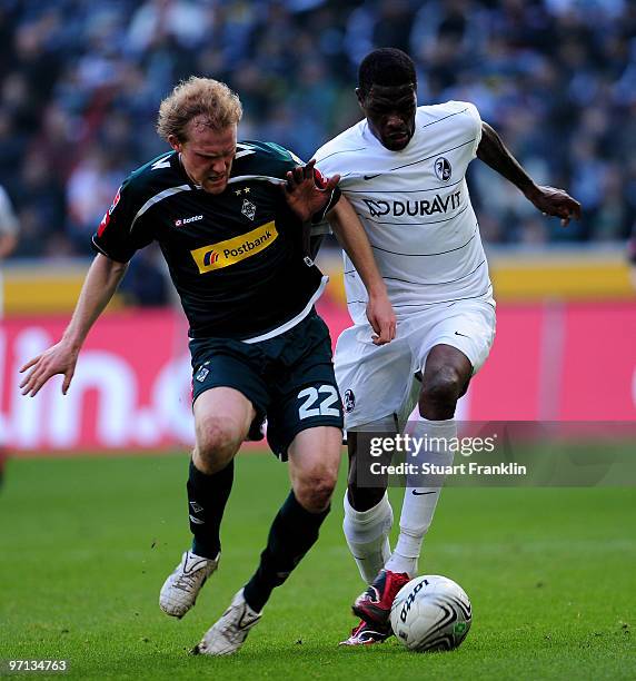 Tobias Levels of Moenchengladbach challenges Mohamadou Idrissou of Freiburg during the Bundesliga match between Borussia Moenchengladbach and SC...