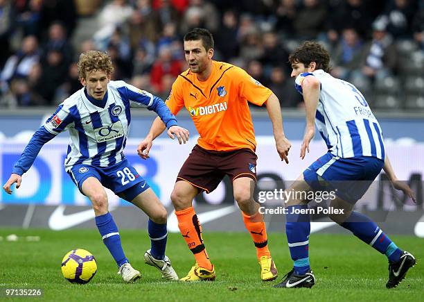 Fabian Lustenberger and Arne Friedrich of Berlin and Vedad Ibisevic of Hoffenheim battle for the ball during the Bundesliga match between Hertha BSC...