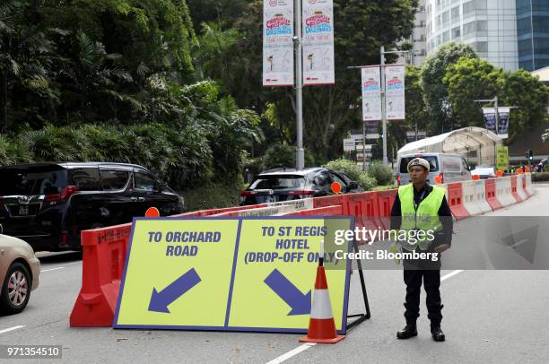 Police officer stands next to the barricades outside the St. Regis hotel, where North Korean leader Kim Jong Un is staying in Singapore, on Monday,...