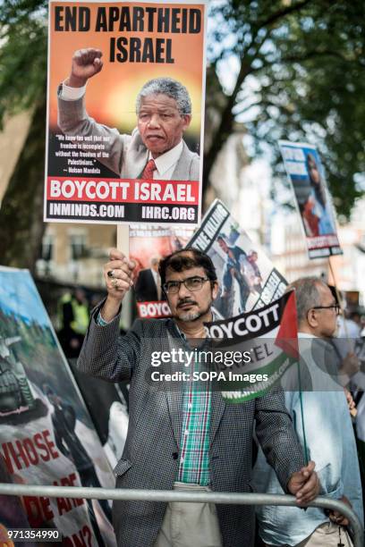 Pic shows a a man holding a banner with Nelson Mandela in the pro-palestina demonstration. Hundreds of anti-Israel protesters marched through the...