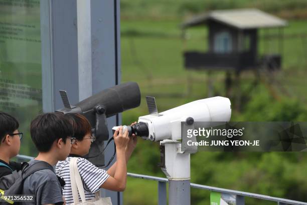 Visitors look through binoculars at a viewing deck of Imjingak peace park near the Demilitarised Zone dividing the two Korea's in the border city of...