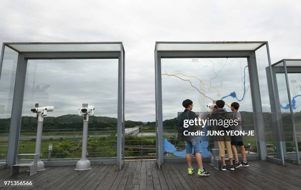 Visitors look through binoculars at a viewing deck of Imjingak peace park near the Demilitarised Zone dividing the two Korea's in the border city of...