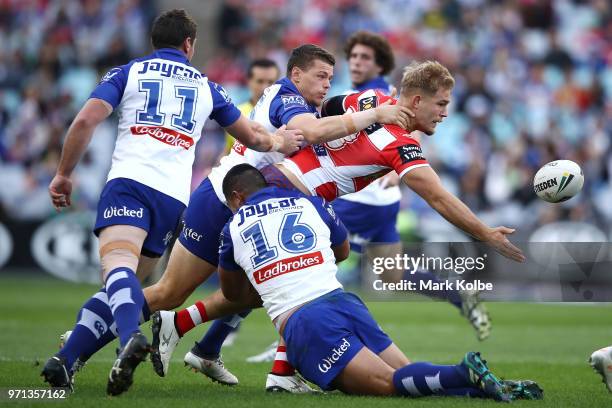 Jack De Belin of the Dragons offloads as he is tackled during the round 14 NRL match between the Canterbury Bulldogs and the St George Illawarra...