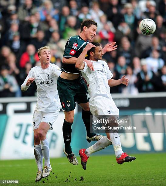 Rob Friend of Moenchengladbach is challenged by Felix Bastians and Pavel Krmas of Freiburg during the Bundesliga match between Borussia...