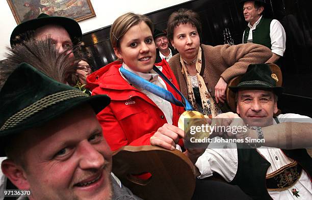 Victoria Rebensburg, Olympic gold medal winner, poses with members of Bavarian dressed brass band during a local reception on February 27, 2010 in...