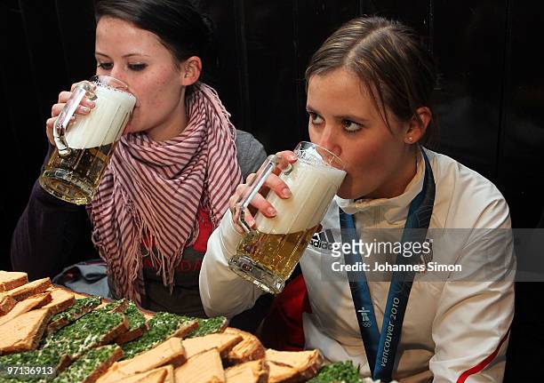 Victoria Rebensburg , Olympic gold medal winner, drinks beer beside of her sister Stephanie during a local reception on February 27, 2010 in...