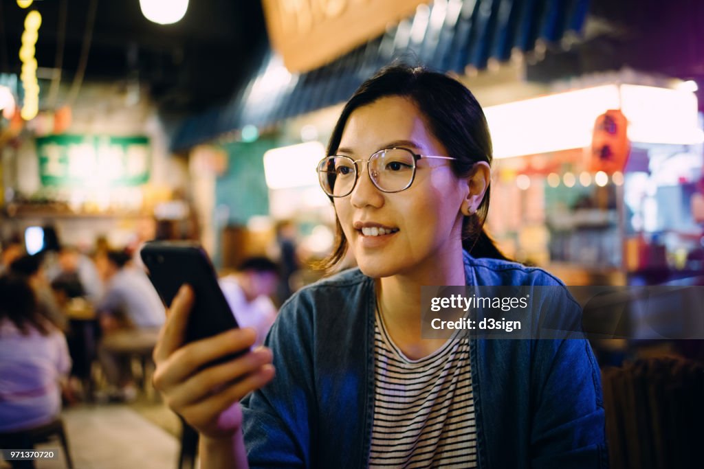 Young woman using smartphone in a traditional style restaurant