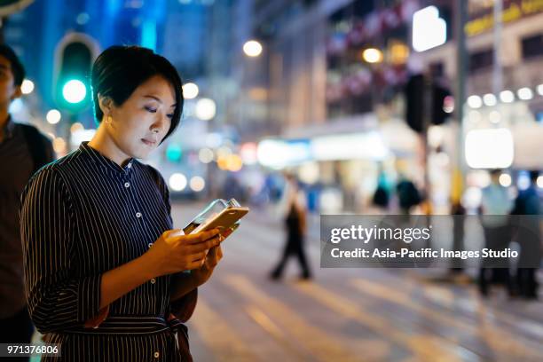 businesswomen using smart phone at street - hong kong woman stock pictures, royalty-free photos & images