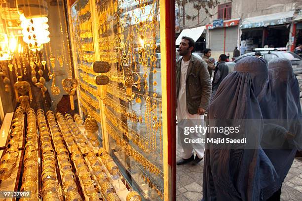 Afghan women look at gold in a window of a jewelry shop February 27, 2010 in Herat, Afghanistan. As the ongoing war in Afghanistan enters its ninth...