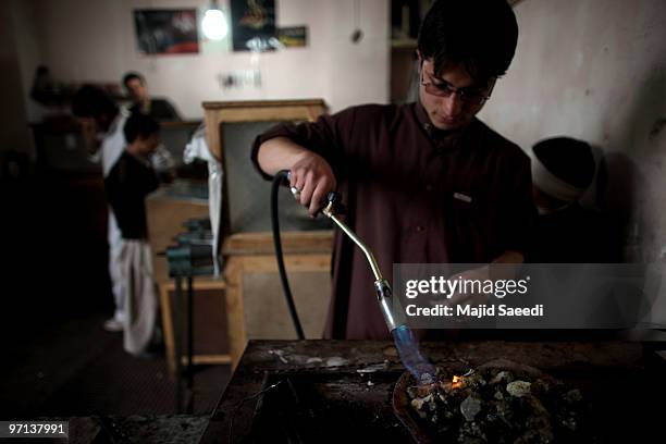 Man melts gold to be re-formed as jewelry in a shop February 27, 2010 in Herat, Afghanistan. As the ongoing war in Afghanistan enters its ninth year...