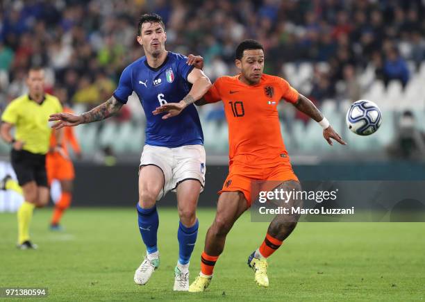 Menphis Depay of Netherlands competes for the ball with Alessio Romagnoli of Italy during the International Friendly match between Italy and...