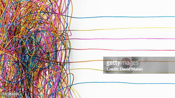 jumble of coloured wires with some straightening out. - ordnung stock-fotos und bilder