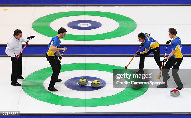 Markus Eggler of Switzerland watches Sebastian Kraupp , Fredrik Lindberg and Viktor Kjaell of Sweden sweep in the Men's Bronze Medal game between...