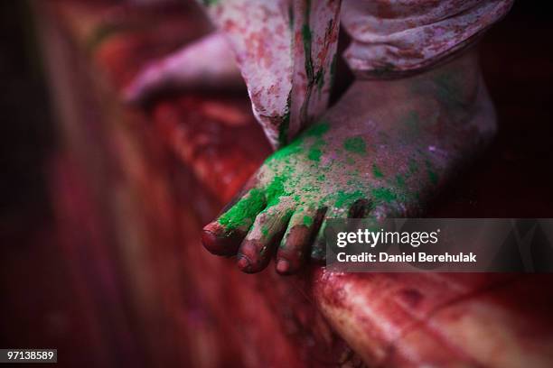 Dye covers the foot of a Hindu devotees as others play with colour during Holi celebrations at the Bankey Bihari Temple on February 27, 2010 in...