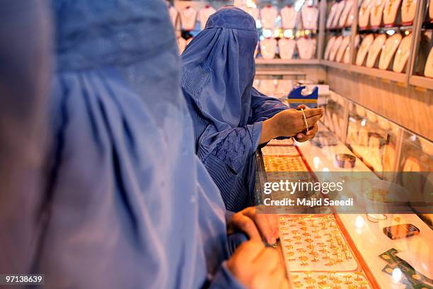Afghan women purchase gold in a jewelry shop February 27, 2010 in Herat, Afghanistan. As the ongoing war in Afghanistan enters its ninth year the...