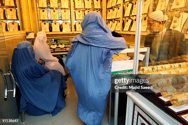 Afghan women purchase gold in a jewelry shop February 27, 2010 in Herat, Afghanistan. As the ongoing war in Afghanistan enters its ninth year the...