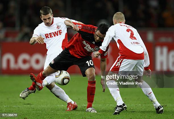 Renato Augusto of Leverkusen and Lukas Podolski battle for the ball as his team mate Miso Brecko of Koeln looks on during the Bundesliga match...