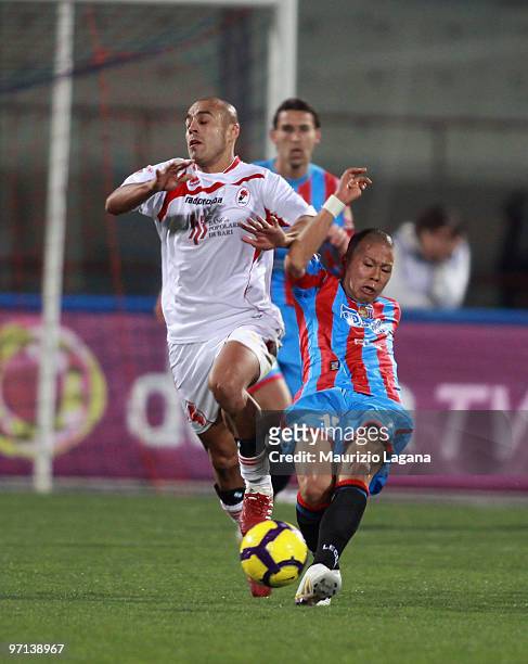 Takayuki Morimoto of Catania Calcio battles for the ball with Sergio Almiron of AS Bari during the Serie A match between Catania and Bari at Stadio...