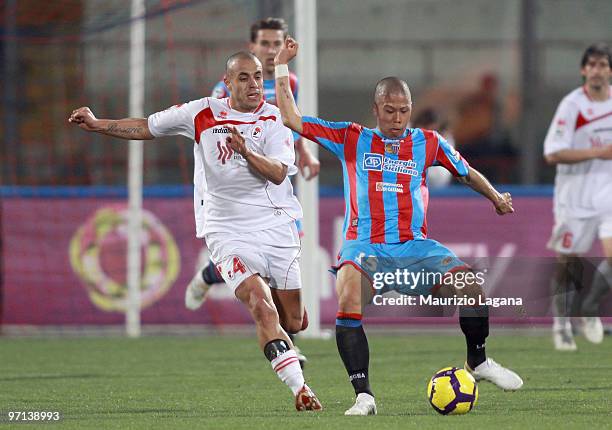 Takayuki Morimoto of Catania Calcio battle for the ball with Sergio Almiron of AS Bari during the Serie A match between Catania and Bari at Stadio...