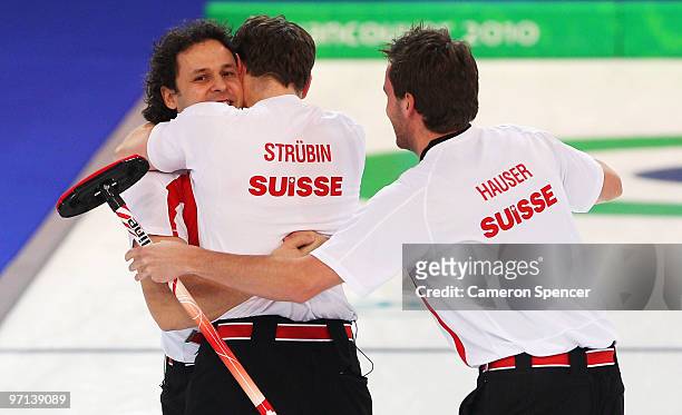Ralph Stoeckli of Switzerland celebrates victory with Simon Struebin and Jan Hauser in the Men's Bronze Medal game between Sweden and Switzerland on...