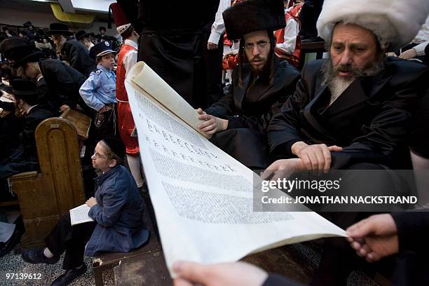 Ultra-Orthodox Jews belonging to the Vishnitz Hassidic sect read the Esther scrolls with children dressed in carnival costume at a synagogue in the...