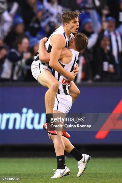 Josh Thomas of the Magpies is congratulated by Taylor Adams after kicking a goal during the round 12 AFL match between the Melbourne Demons and the...