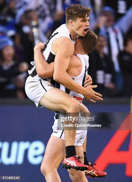 Josh Thomas of the Magpies is congratulated by Taylor Adams after kicking a goal during the round 12 AFL match between the Melbourne Demons and the...