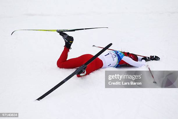 Justyna Kowalczyk of Poland collapses after crossing the finish line in first place during the ladies' 30 km mass start cross-country skiing classic...