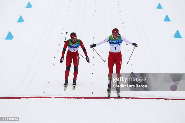 Justyna Kowalczyk of Poland crosses the finish line in first place ahead of Marit Bjoergen of Norway during the ladies' 30 km mass start...