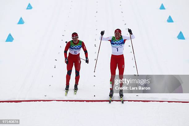 Justyna Kowalczyk of Poland crosses the finish line in first place ahead of Marit Bjoergen of Norway during the ladies' 30 km mass start...