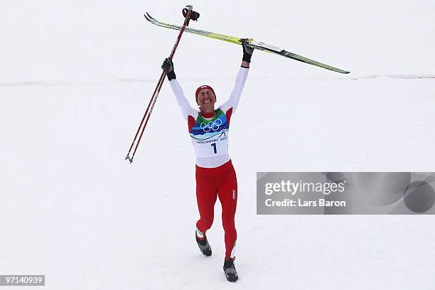 Justyna Kowalczyk of Poland celebrates winning the gold medal in the ladies' 30 km mass start cross-country skiing classic on day 16 of the 2010...