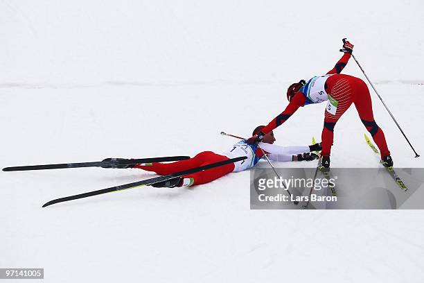 Justyna Kowalczyk of Poland and Marit Bjoergen of Norway react after winning the gold and silver medals in the ladies' 30 km mass start cross-country...