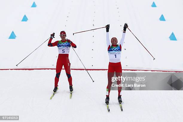 Justyna Kowalczyk of Poland celebrates crossing the finish line in first place ahead of Marit Bjoergen of Norway during the ladies' 30 km mass start...