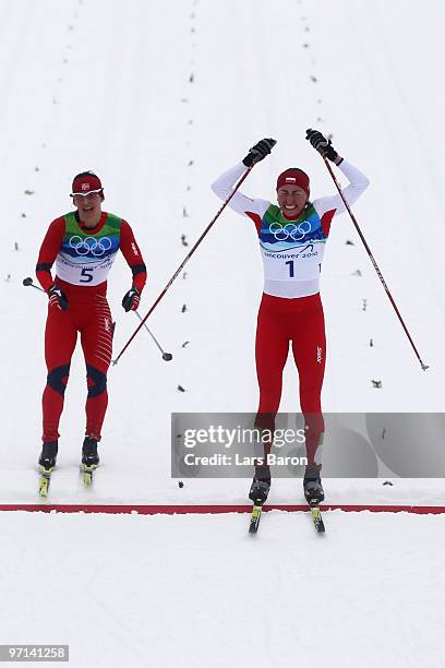 Justyna Kowalczyk of Poland celebrates crossing the finish line in first place ahead of Marit Bjoergen of Norway during the ladies' 30 km mass start...