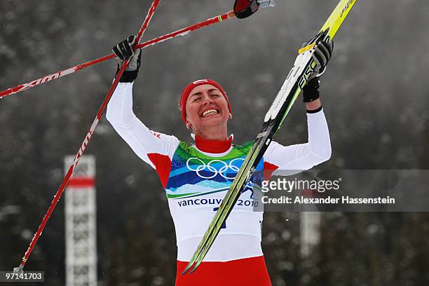 Justyna Kowalczyk of Poland celebrates winning the gold medal in the ladies' 30 km mass start cross-country skiing classic on day 16 of the 2010...