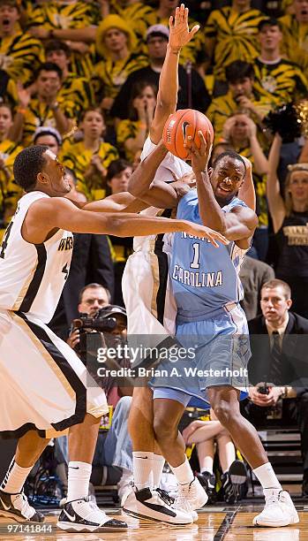 Marcus Ginyard of the North Carolina Tar Heels is double teamed by David Weaver and Ari Stewart of the Wake Forest Demon Deacons on February 27, 2010...