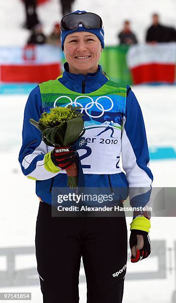 Aino-Kaisa Saarinen of Finland celebrates winning the bronze medal during the flower ceremony for the flower ceremony for the ladies' 30 km mass...