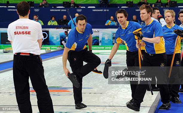Sweden players removes their shoe covers as Swiss player Simon Struebin look on during a match for the bronze medal at the 2010 Olympics in...