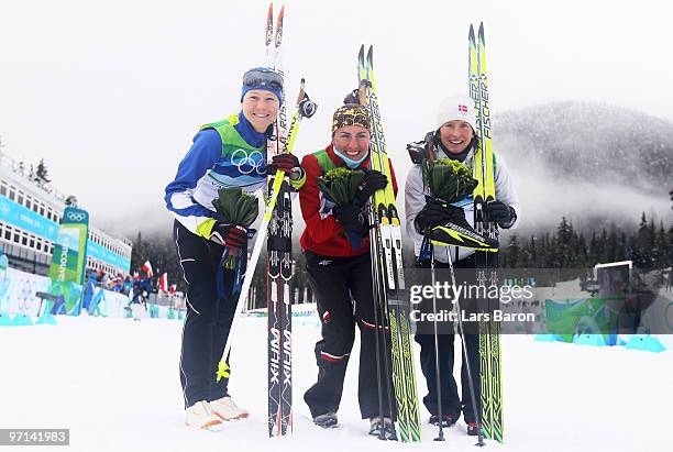 Aino-Kaisa Saarinen of Finland celebrates winning bronze, Justyna Kowalczyk of Poland gold and Marit Bjoergen of Norway silver in the ladies' 30 km...