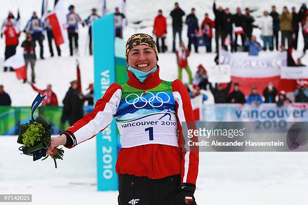 Justyna Kowalczyk of Poland celebrates winning the gold medal during the flower ceremony for the ladies' 30 km mass start cross-country skiing...